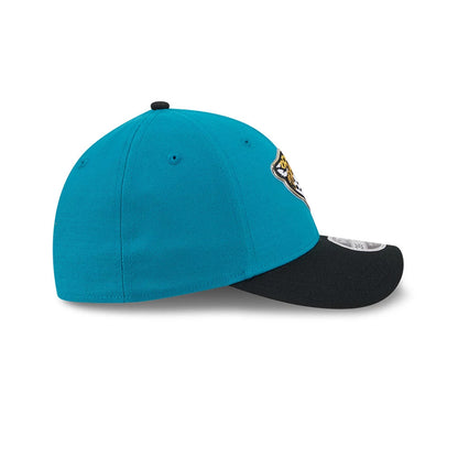 Jaguars NFL Draft 2026 Turquoise New Era 39THIRTY M-Crown Stretch Fit Cap, side view showing the turquoise structured crown with matching eyelets, a black curved visor with a 39THIRTY size sticker, and the Jaguars logo on the front panel.