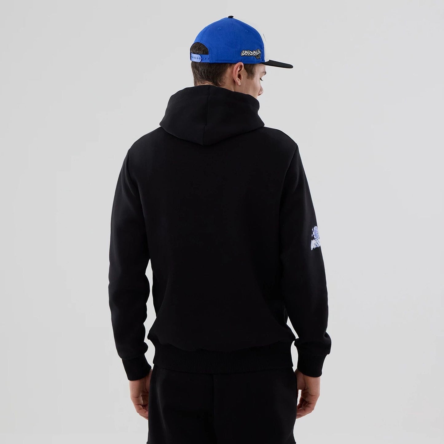 The model is wearing this NBA London Game 2026 Orlando Magic Pullover Hoodie in black. 2