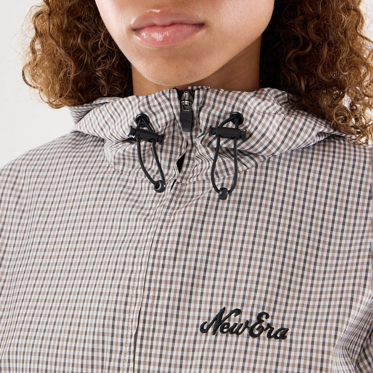 The model is wearing this Womens New Era Check Oversized Windbreaker Jacket in beige. 4