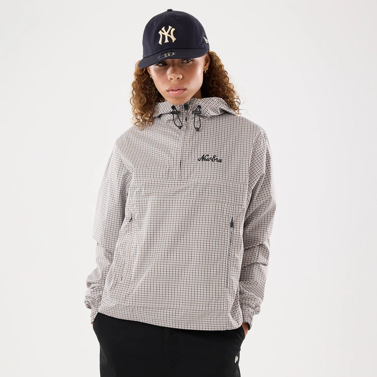 The model is wearing this Womens New Era Check Oversized Windbreaker Jacket in beige. 1