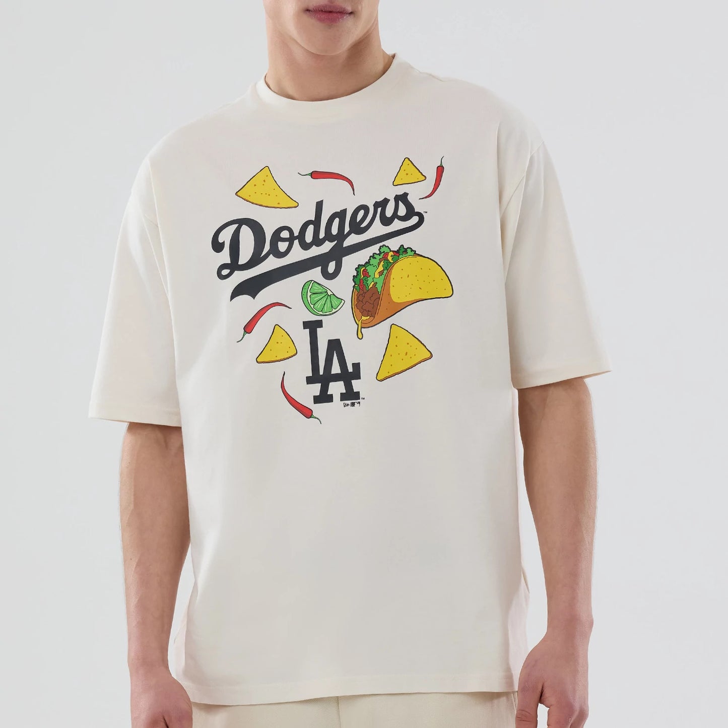 The model is wearing this MLB Food Graphic LA Dodgers Oversized T-Shirt in open white. 4