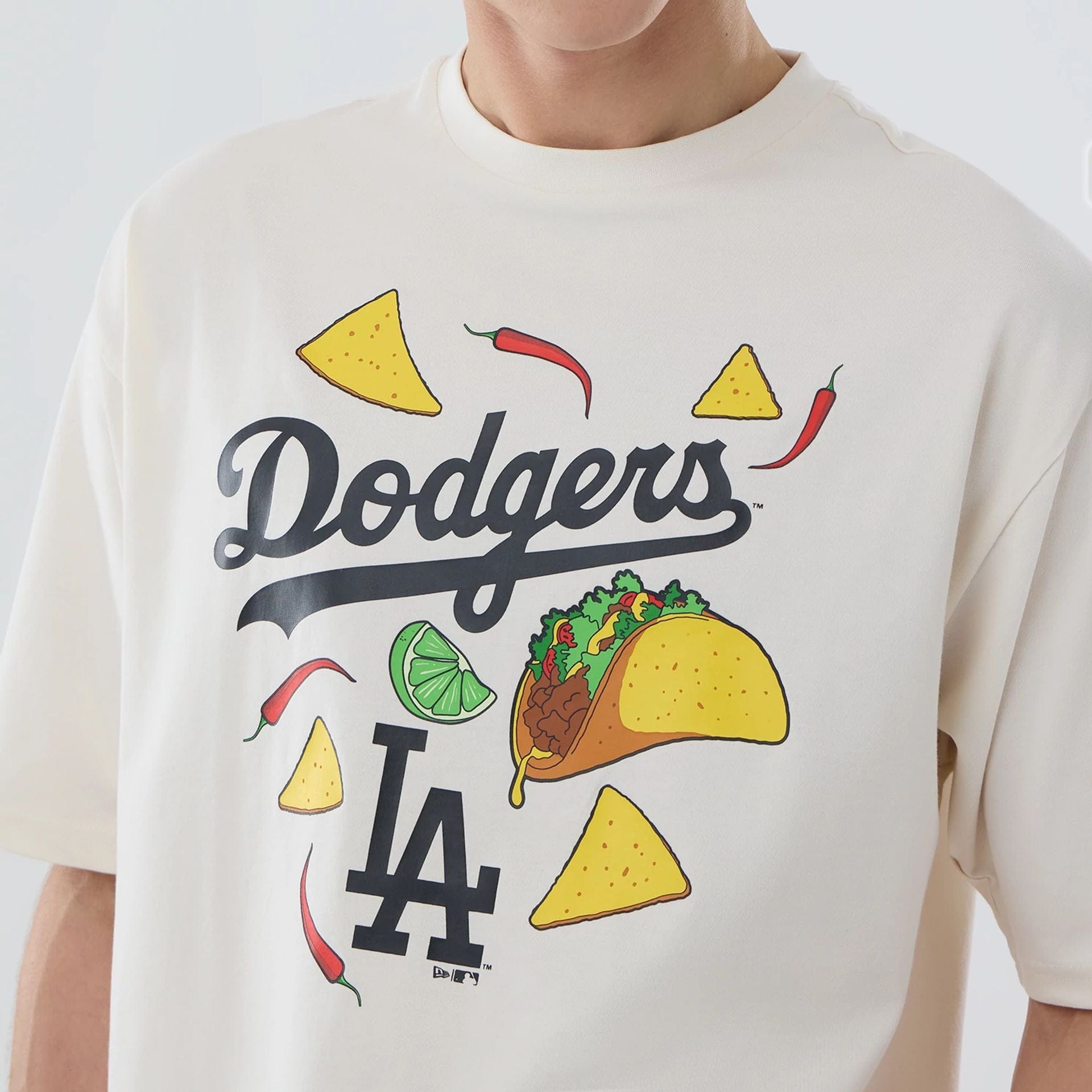 The model is wearing this MLB Food Graphic LA Dodgers Oversized T-Shirt in open white. 3