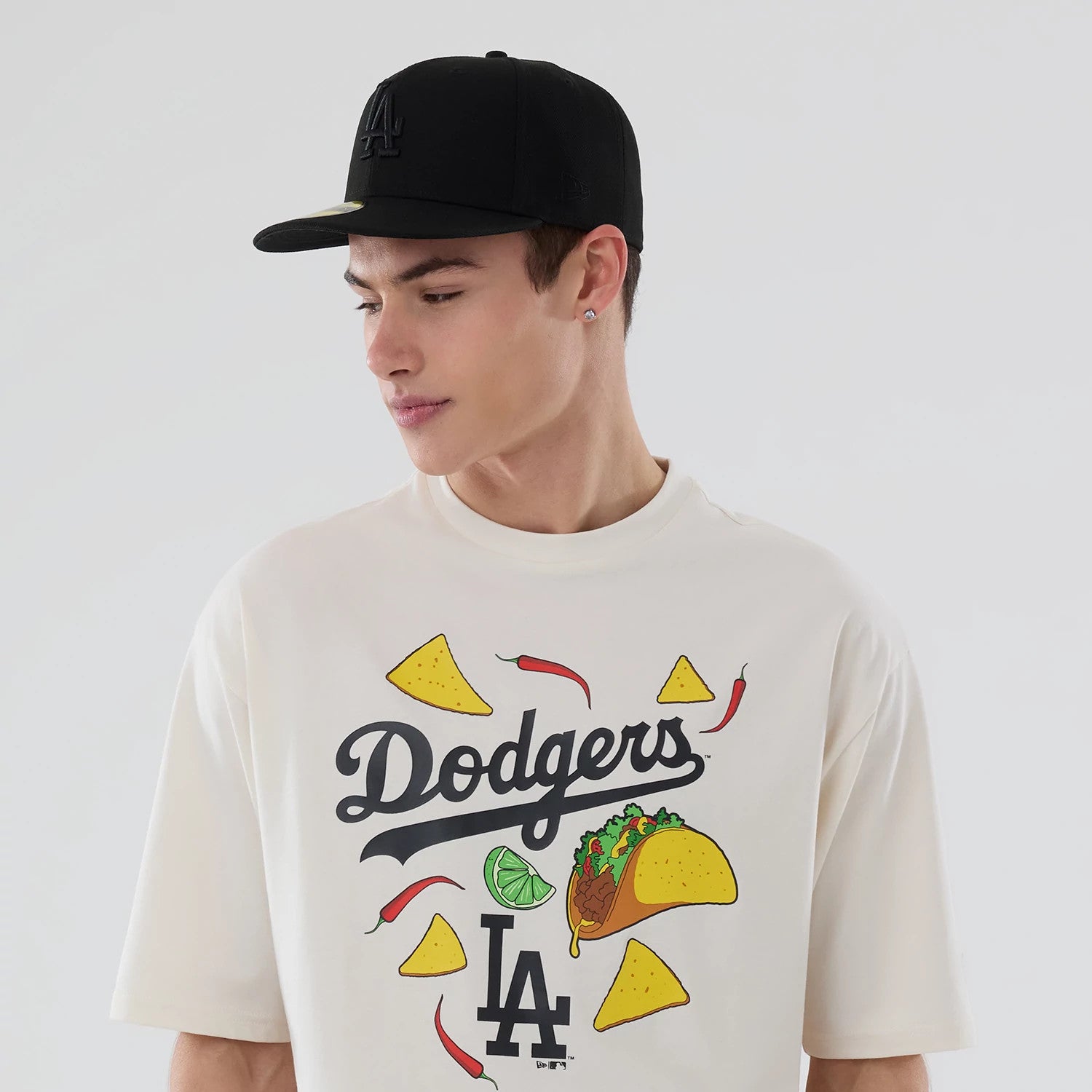 The model is wearing this MLB Food Graphic LA Dodgers Oversized T-Shirt in open white. 6
