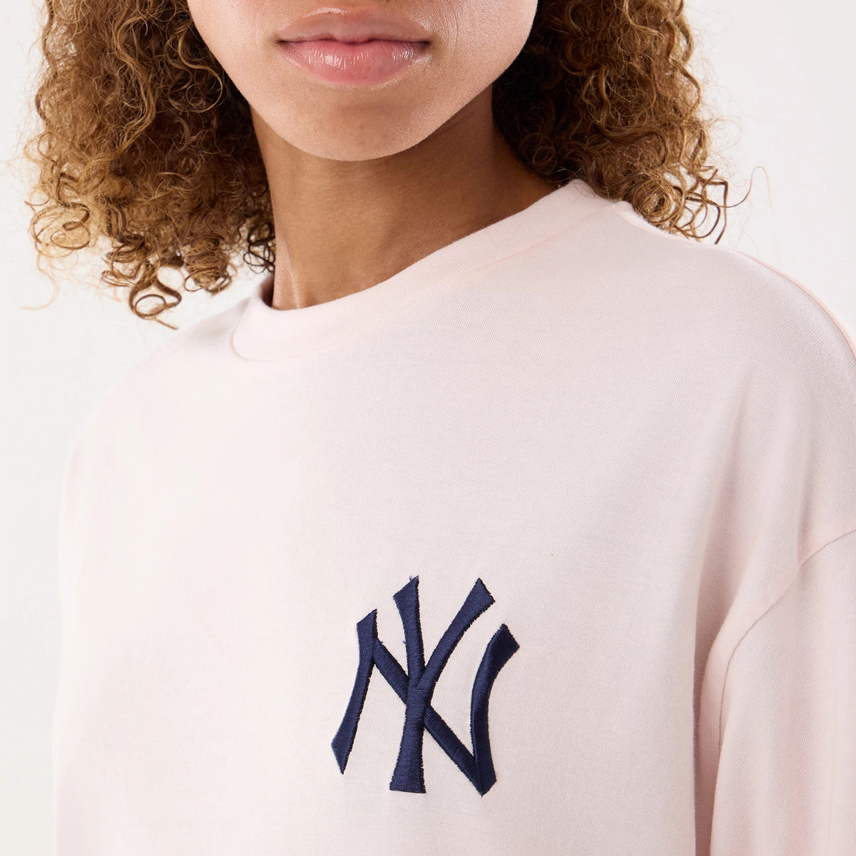 The model is wearing this Womens MLB Graphic New York Yankees T-Shirt in pastel pink. 3