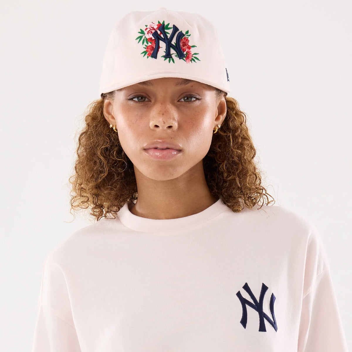 The model is wearing this Womens MLB Graphic New York Yankees T-Shirt in pastel pink. 6