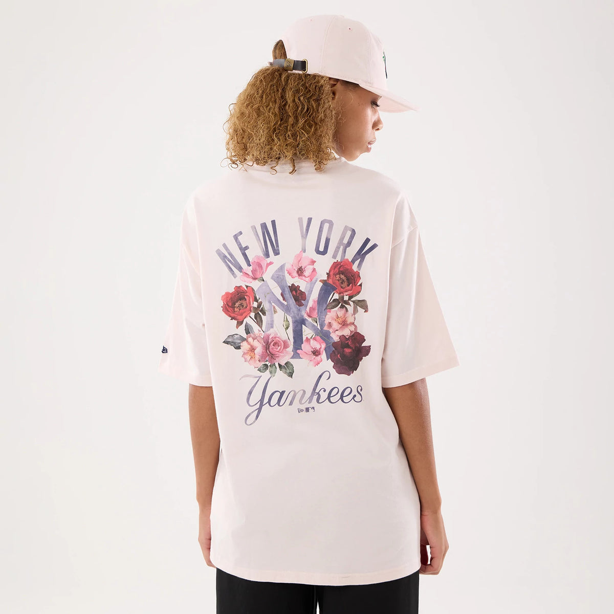 The model is wearing this Womens MLB Graphic New York Yankees T-Shirt in pastel pink. 2