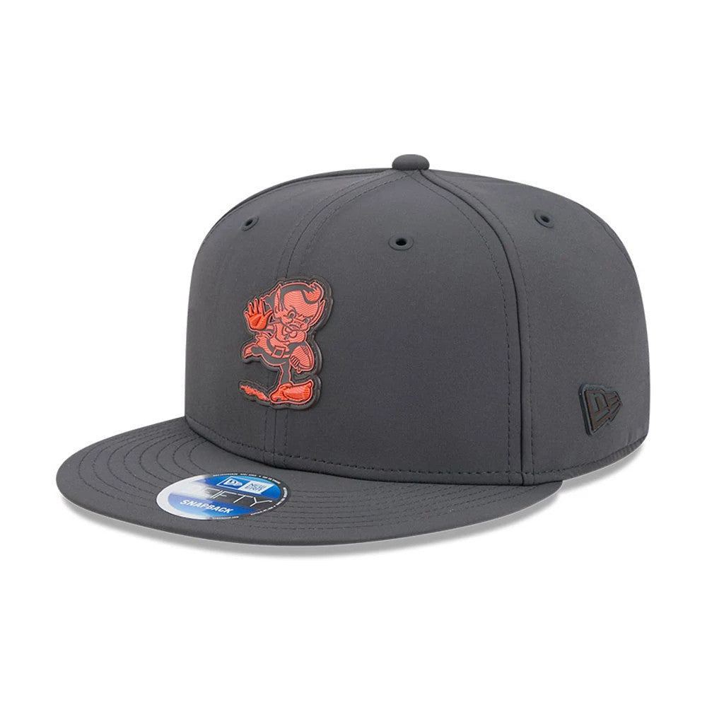 Browns NFL Sideline 2026 Charcoal New Era 9FIFTY Snapback Adjustable Cap, three-quarter view showing the raised orange Browns mascot logo on the front panel, structured charcoal crown with matching top button, and 9FIFTY size sticker on the visor.