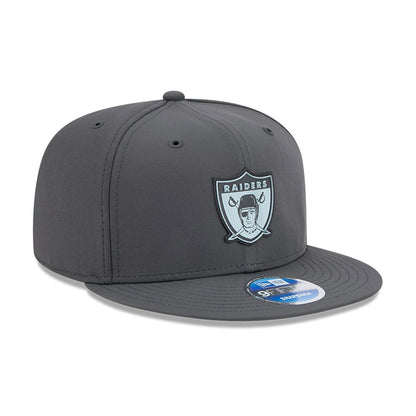 Raiders NFL Sideline 2026 Charcoal New Era 9FIFTY Snapback Adjustable Cap, front view showing the raised Raiders logo embroidered on the front panel in grey and white, with a matching dark grey flat visor and a 9FIFTY size sticker on top.