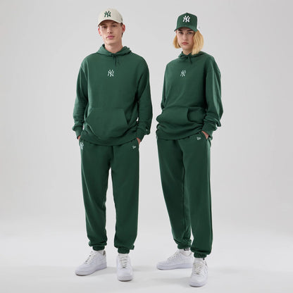 The model is wearing this MLB Midi League Essential New York Yankees Oversized Pullover Hoodie in dark green. 1