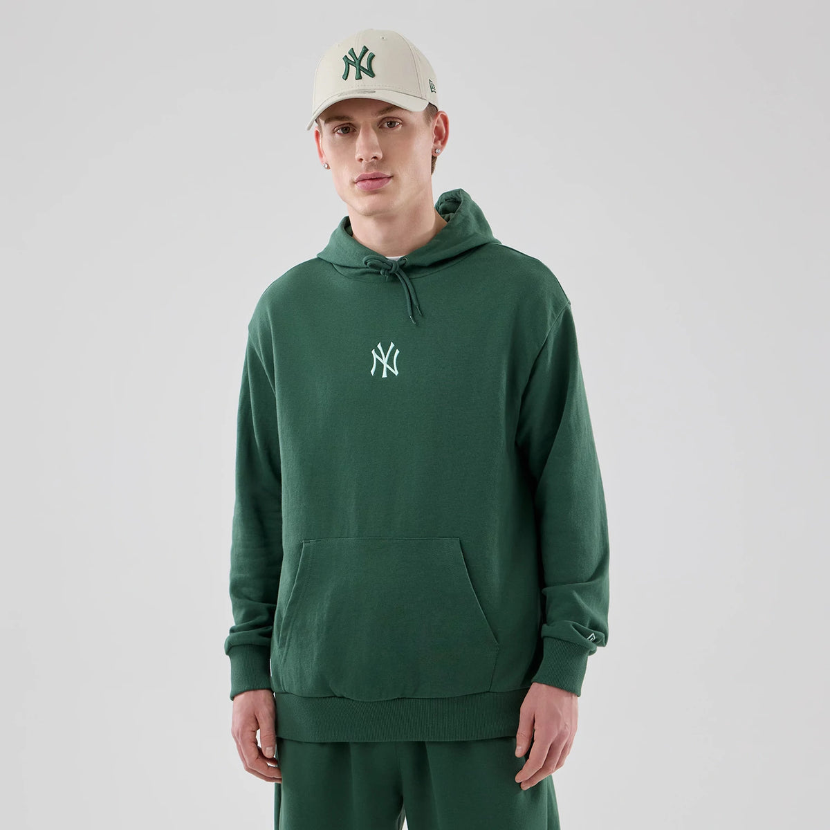 The model is wearing this MLB Midi League Essential New York Yankees Oversized Pullover Hoodie in dark green. 3