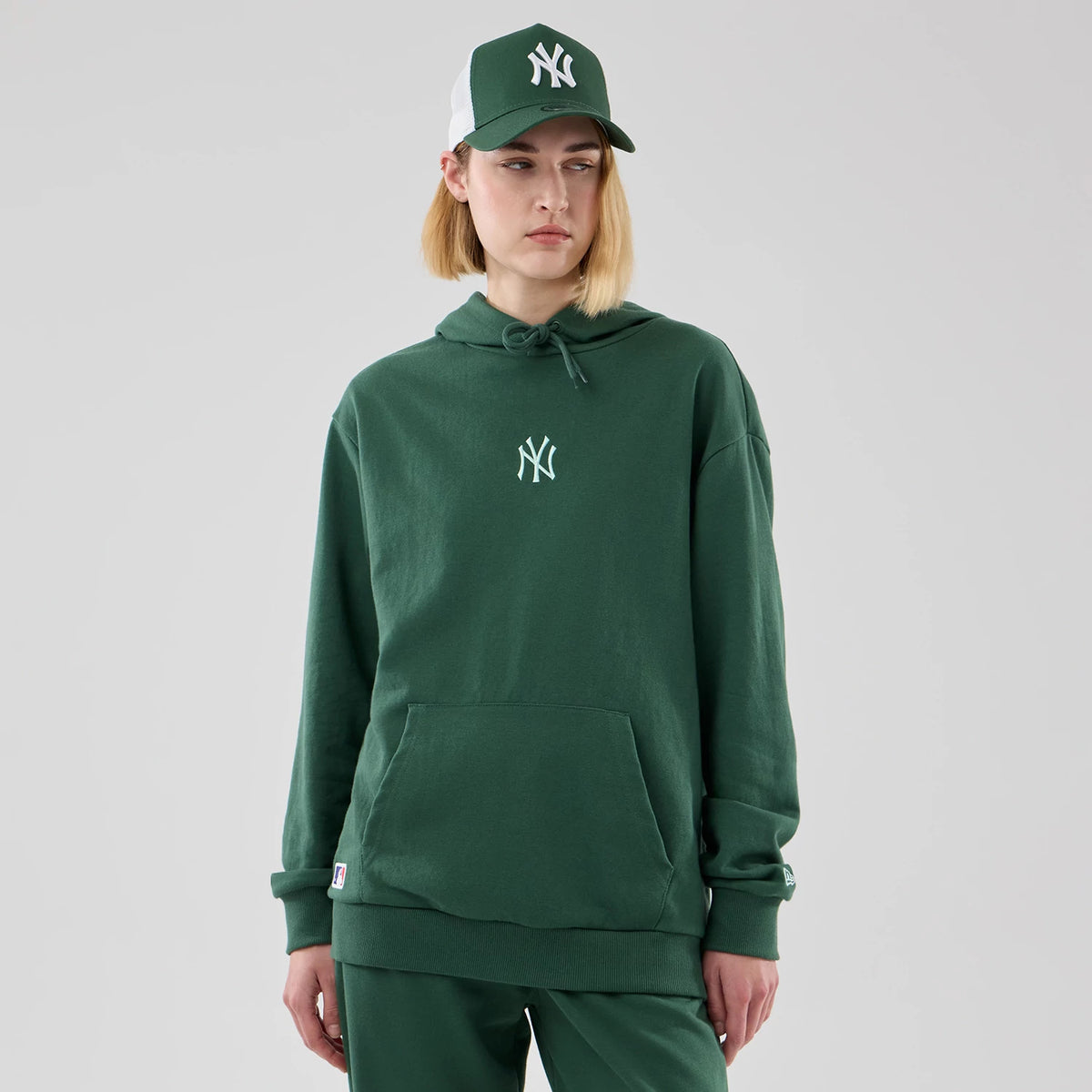 The model is wearing this MLB Midi League Essential New York Yankees Oversized Pullover Hoodie in dark green. 4
