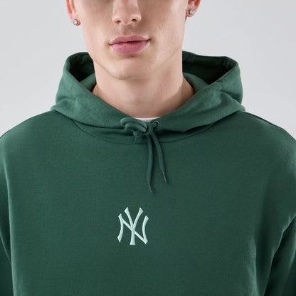 The model is wearing this MLB Midi League Essential New York Yankees Oversized Pullover Hoodie in dark green. 5