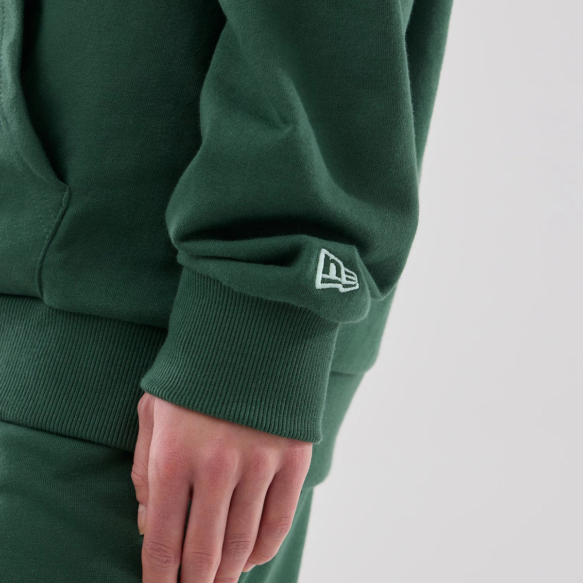 The model is wearing this MLB Midi League Essential New York Yankees Oversized Pullover Hoodie in dark green. 7