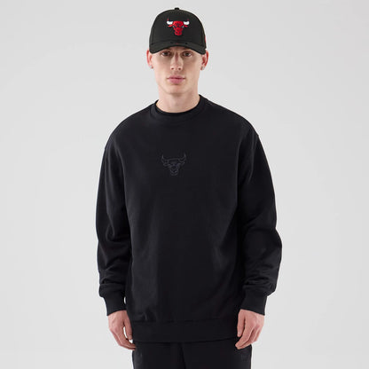 The model is wearing this NBA League Essential Chicago Bulls Oversized Crew Neck Sweater in black. 1