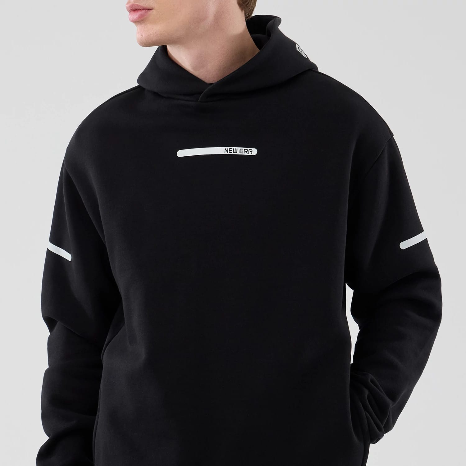 The model is wearing this New Era Tech Oversized Pullover Hoodie in black. 3