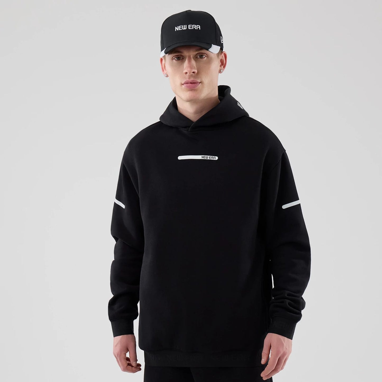 The model is wearing this New Era Tech Oversized Pullover Hoodie in black. 1