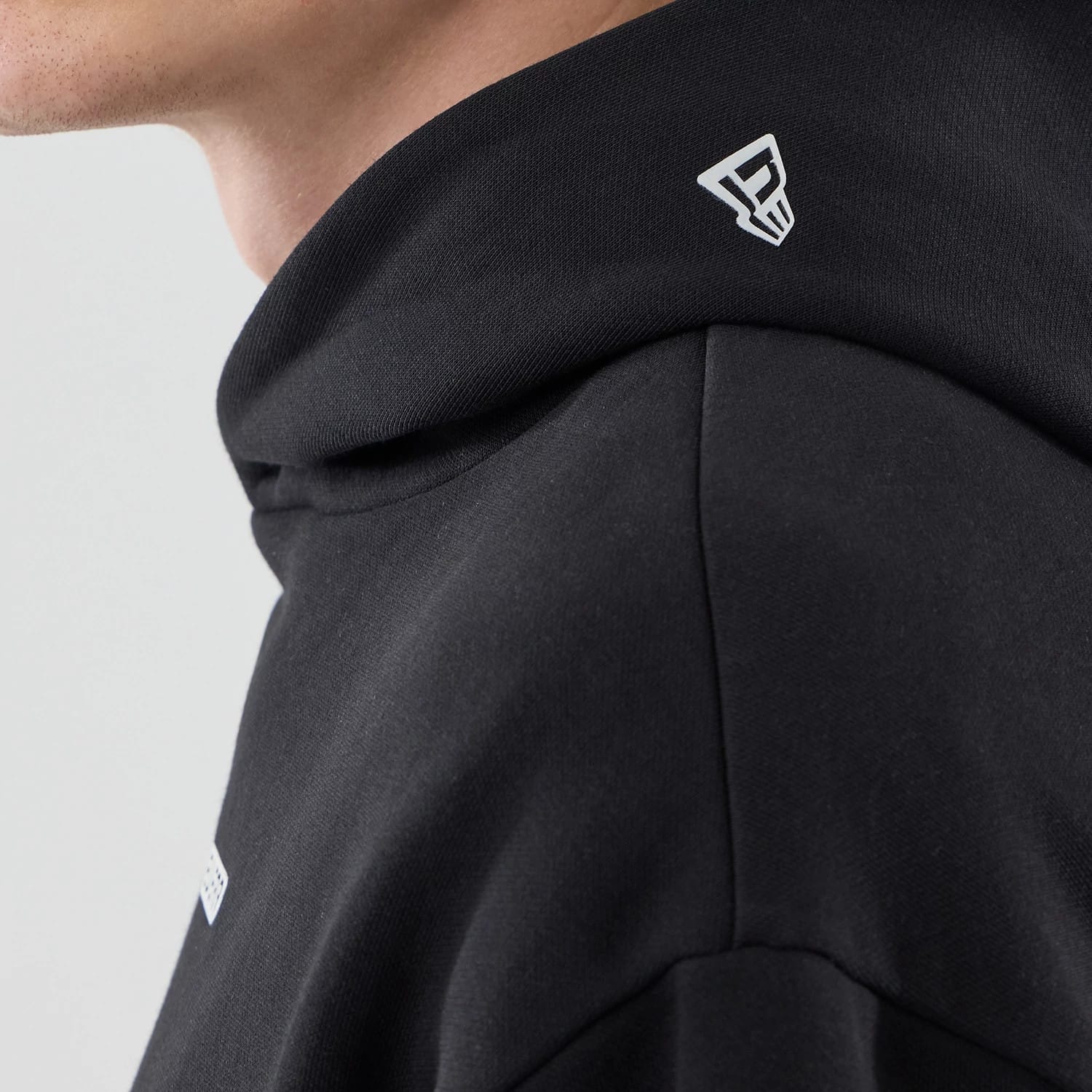 The model is wearing this New Era Tech Oversized Pullover Hoodie in black. 5
