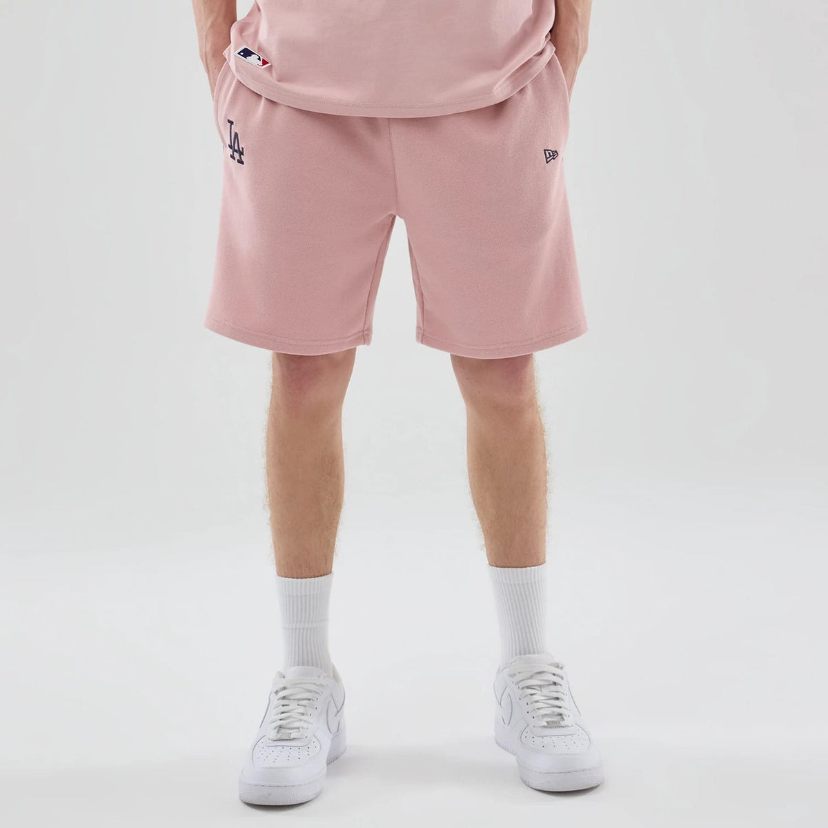 The model is wearing these MLB Midi League Essential LA Dodgers Oversized Shorts in pastel pink. 1
