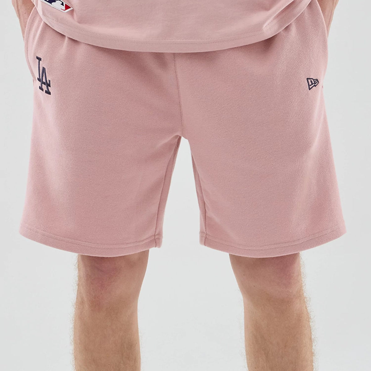 The model is wearing these MLB Midi League Essential LA Dodgers Oversized Shorts in pastel pink. 3