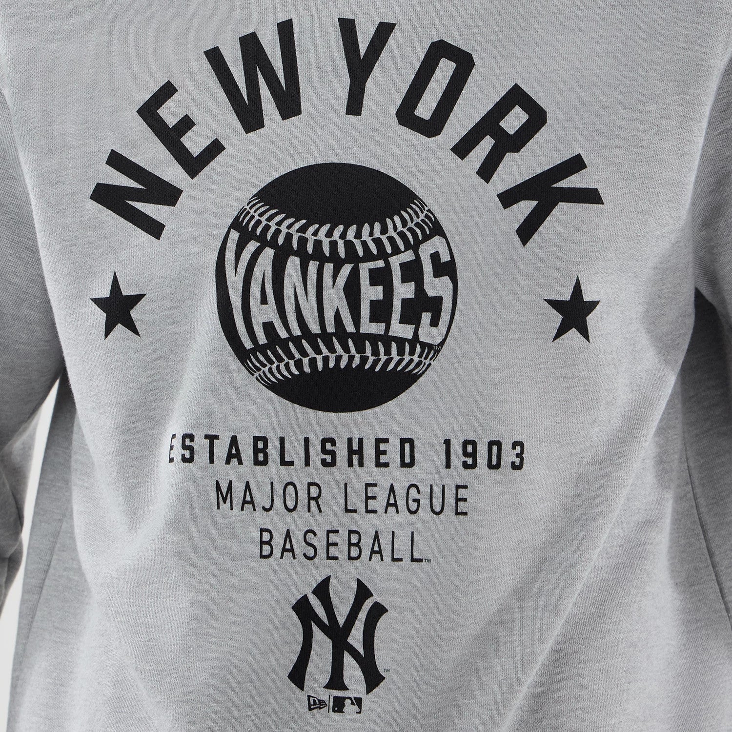 The model is wearing this MLB Graphic New York Yankees Oversized Crew Neck Sweater in grey. 5