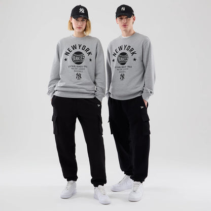 The model is wearing this MLB Graphic New York Yankees Oversized Crew Neck Sweater in grey. 1