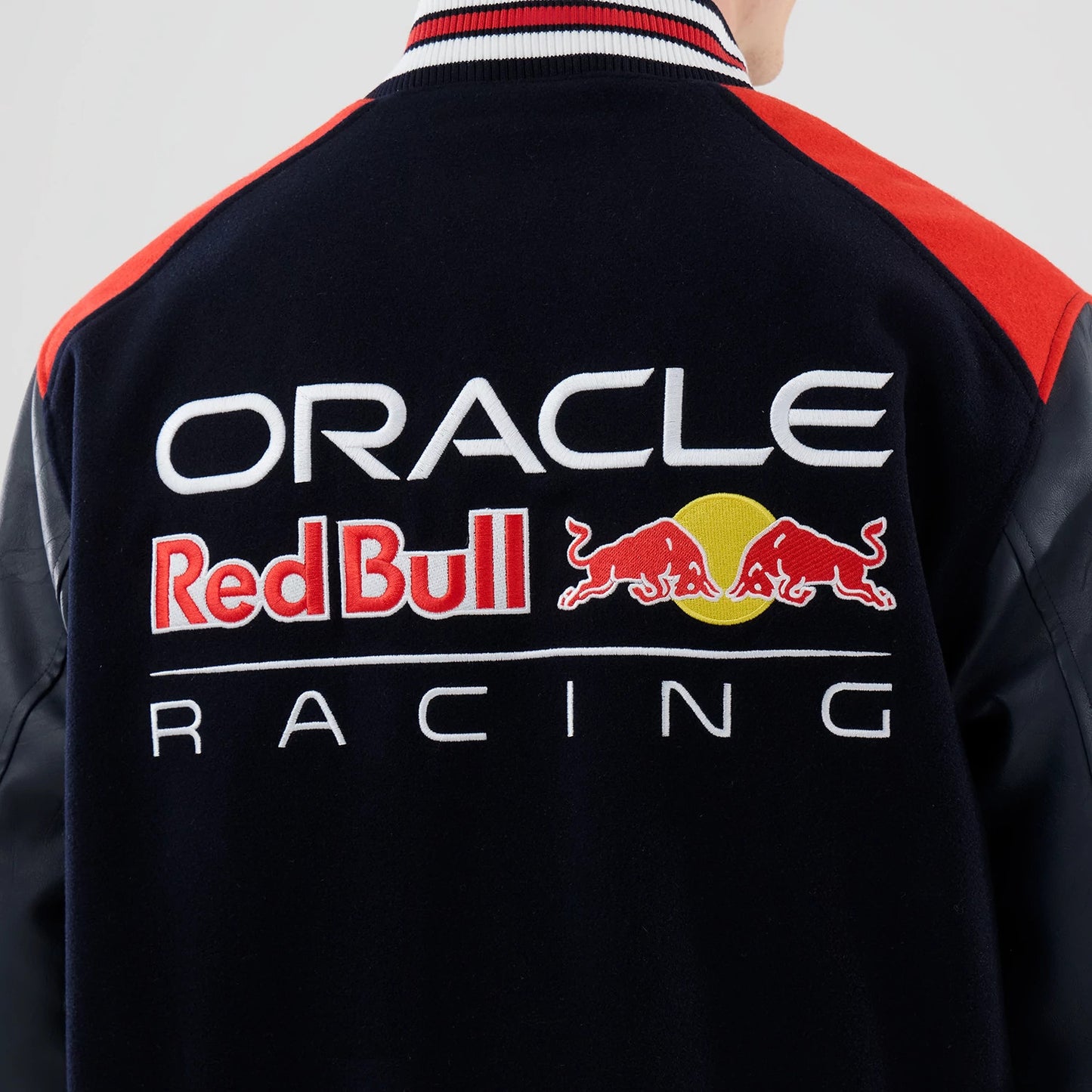 The model is wearing this Red Bull Racing wordmark Varsity Jacket in dark blue. 7