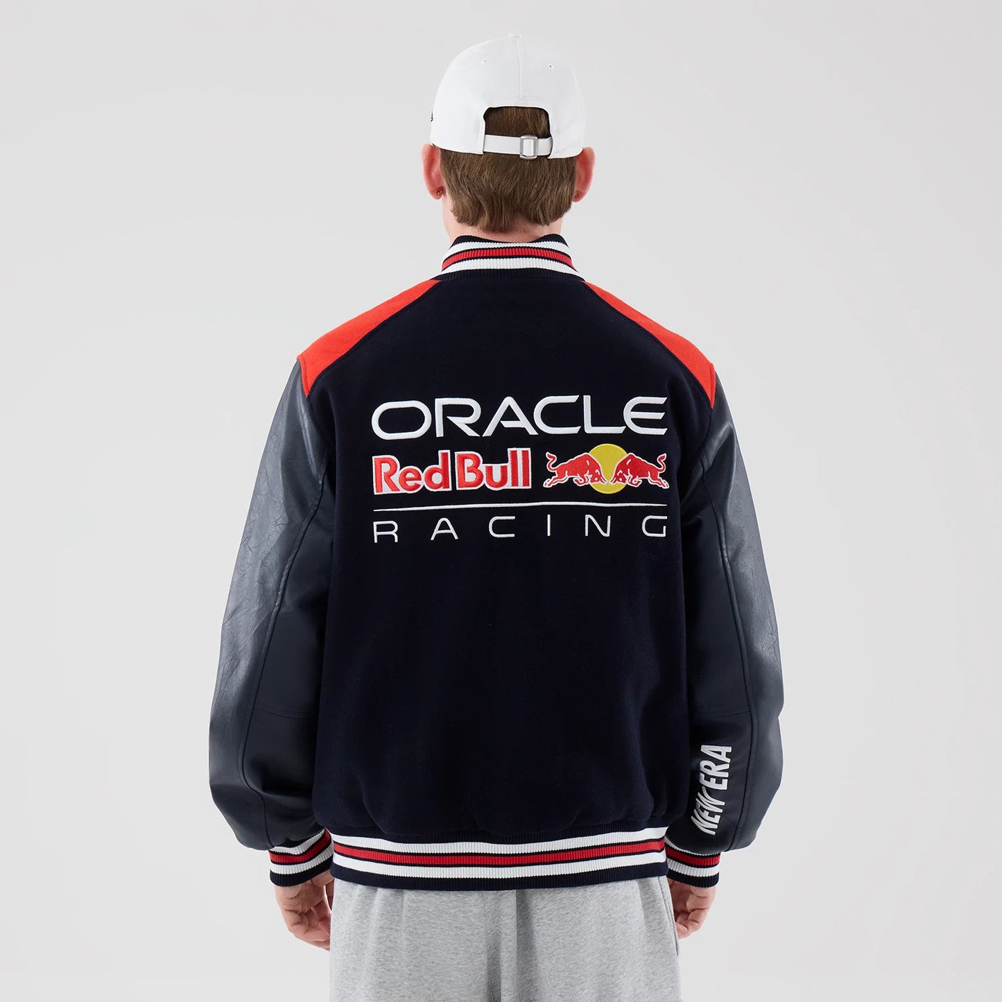 The model is wearing this Red Bull Racing wordmark Varsity Jacket in dark blue. 2