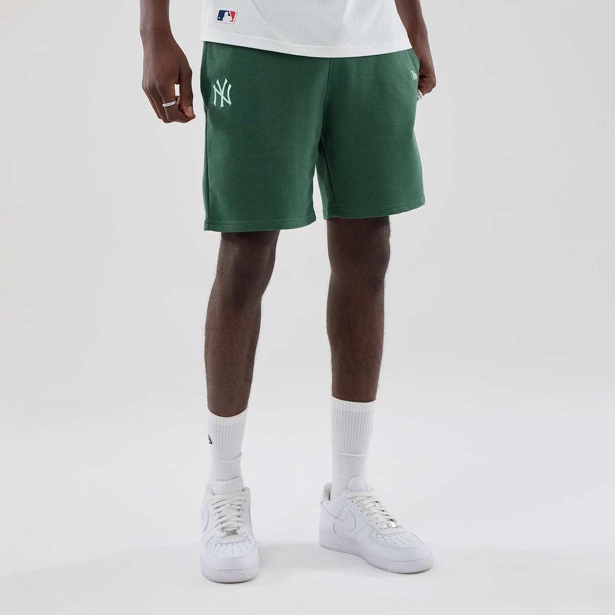 The model is wearing these MLB Midi League Essential New York Yankees Oversized Shorts in dark green. 1