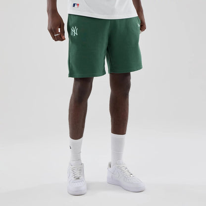 The model is wearing these MLB Midi League Essential New York Yankees Oversized Shorts in dark green. 1