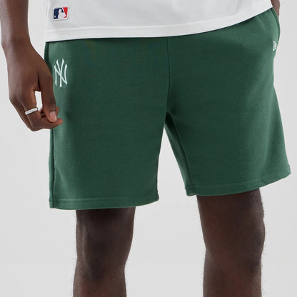 The model is wearing these MLB Midi League Essential New York Yankees Oversized Shorts in dark green. 3