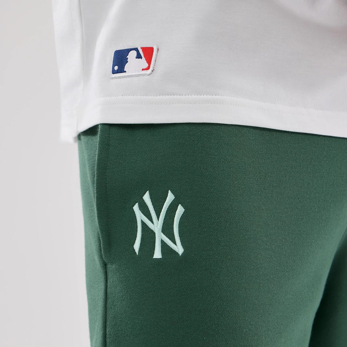 The model is wearing these MLB Midi League Essential New York Yankees Oversized Shorts in dark green. 4