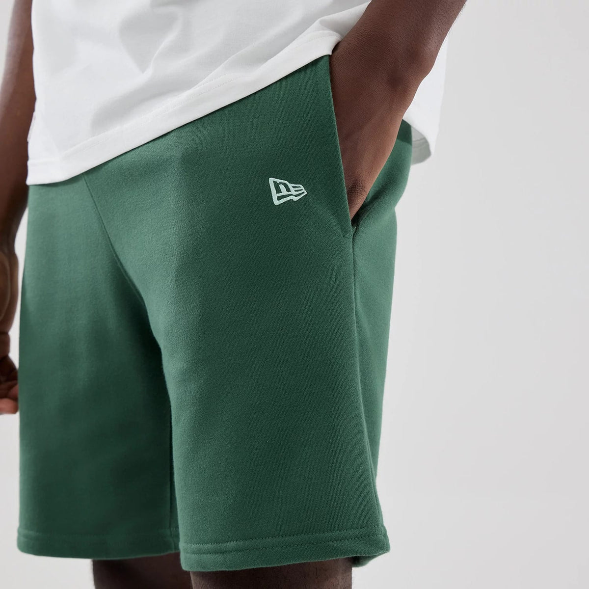 The model is wearing these MLB Midi League Essential New York Yankees Oversized Shorts in dark green. 5