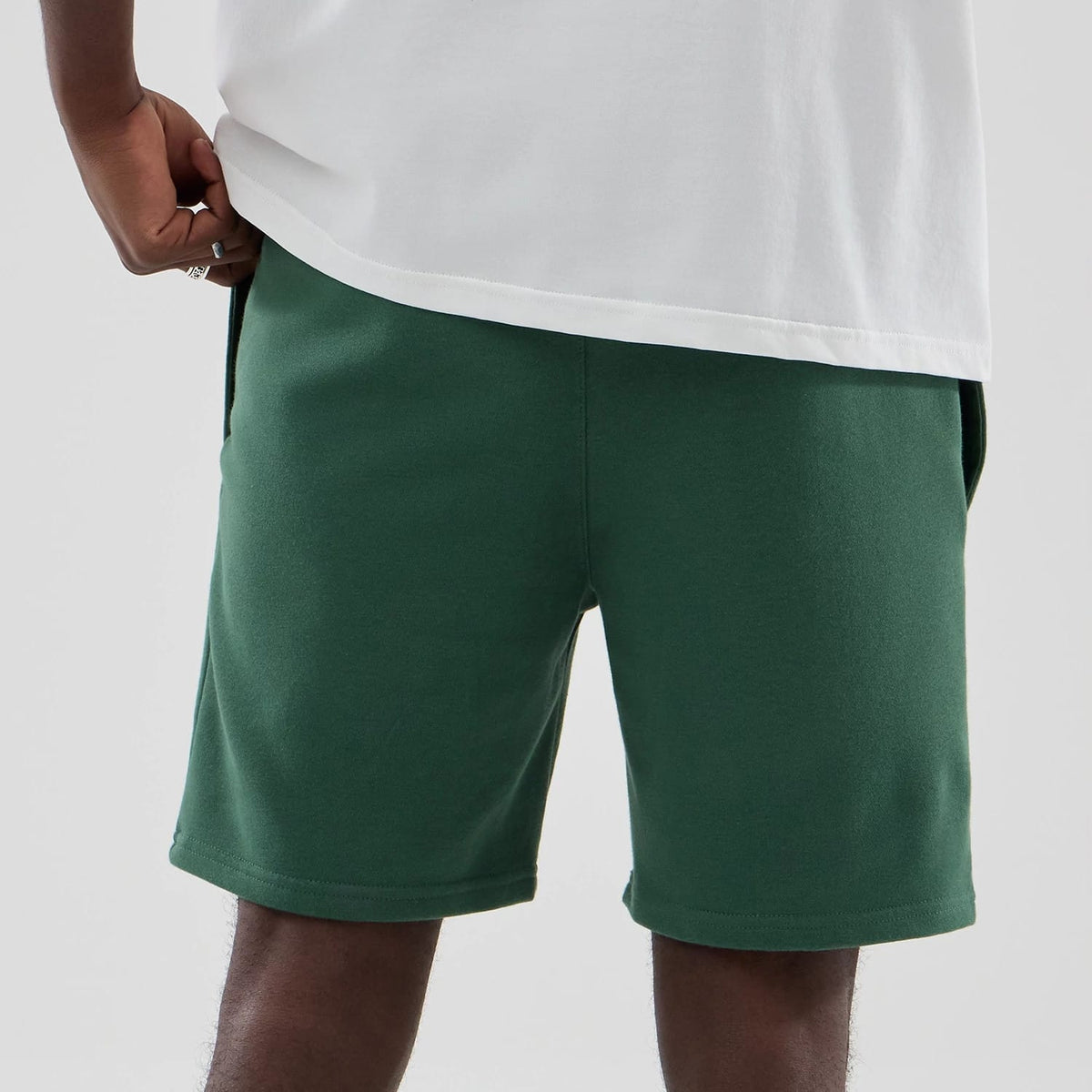 The model is wearing these MLB Midi League Essential New York Yankees Oversized Shorts in dark green. 7