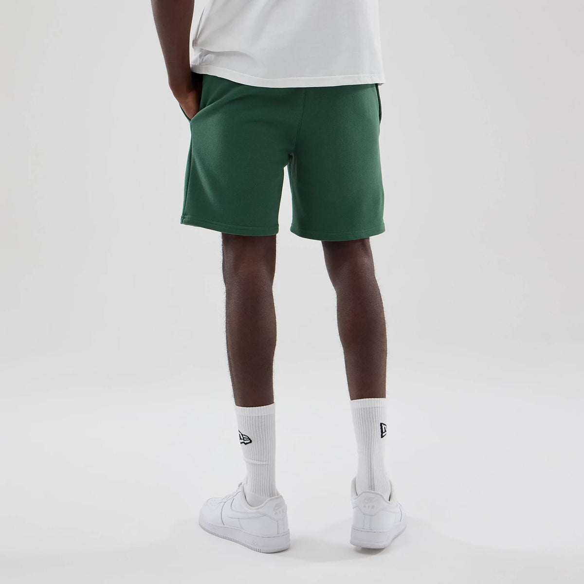 The model is wearing these MLB Midi League Essential New York Yankees Oversized Shorts in dark green. 2