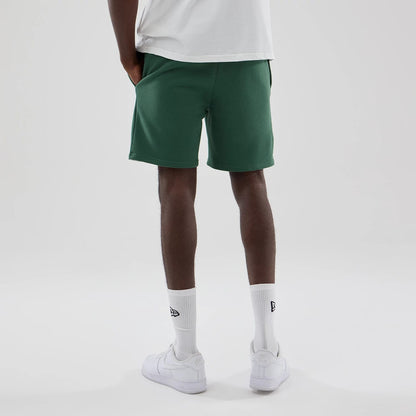 The model is wearing these MLB Midi League Essential New York Yankees Oversized Shorts in dark green. 2