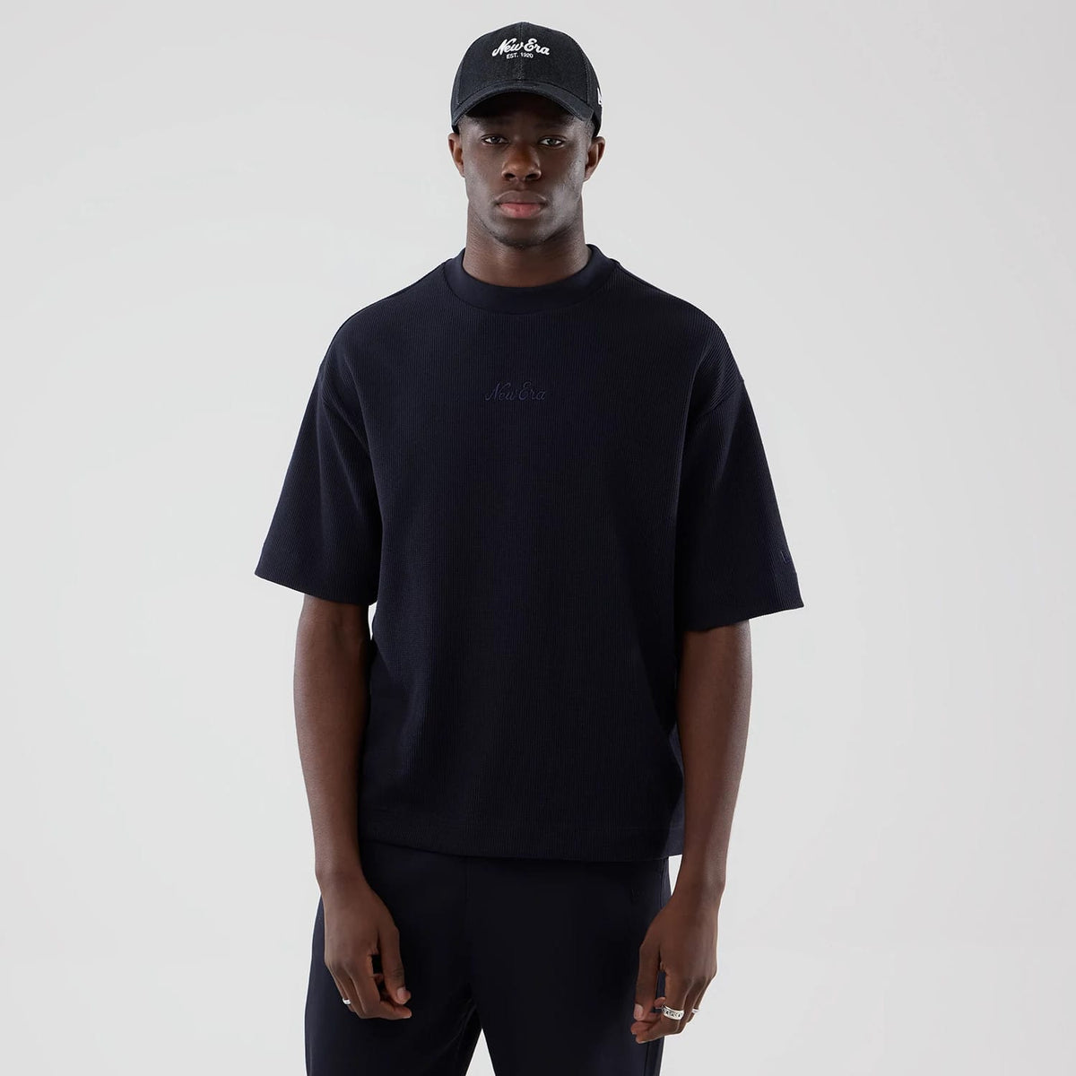The model is wearing this New Era Waffle Boxy T-Shirt in navy. 1