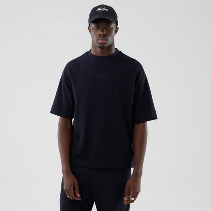The model is wearing this New Era Waffle Boxy T-Shirt in navy. 1
