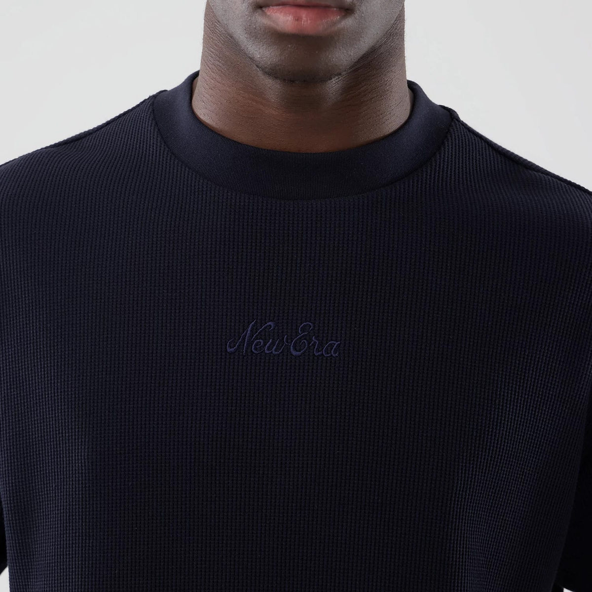The model is wearing this New Era Waffle Boxy T-Shirt in navy. 4