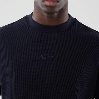 The model is wearing this New Era Waffle Boxy T-Shirt in navy. 4