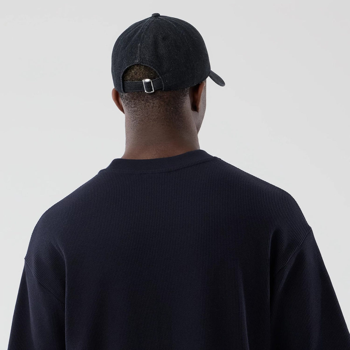 The model is wearing this New Era Waffle Boxy T-Shirt in navy. 7