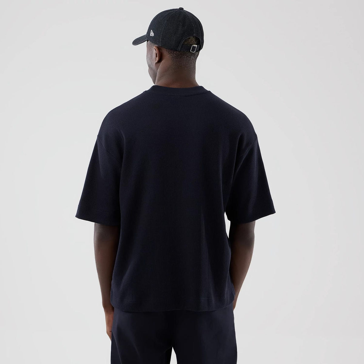 The model is wearing this New Era Waffle Boxy T-Shirt in navy. 2