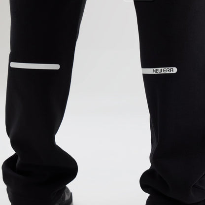 New Era Tech Reflective Black Straight Leg Joggers, close-up view showing reflective strips above the knee, with a white New Era logo on the right leg and black fabric for a modern look.