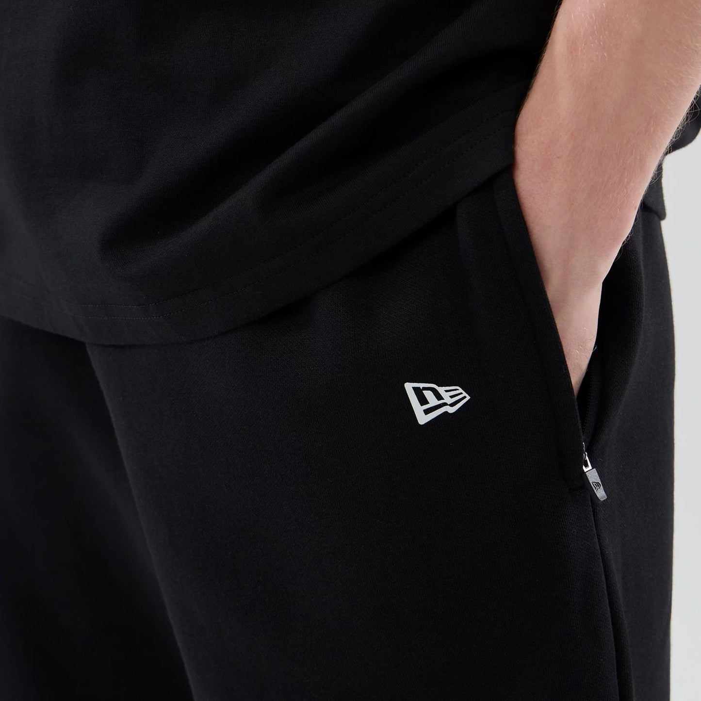 The model is wearing these New Era Tech Reflective Straight Leg Joggers in black. 5