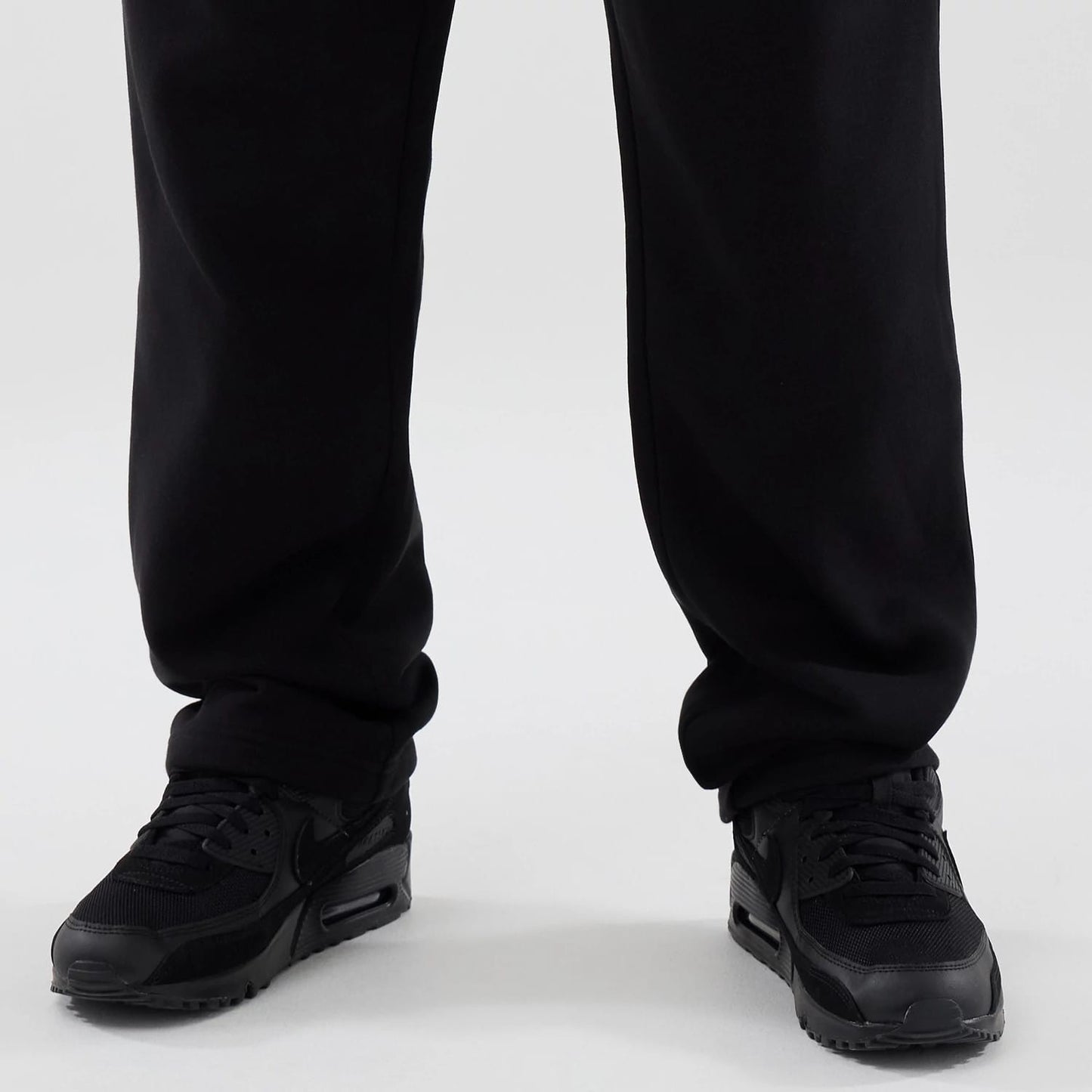 The model is wearing these New Era Tech Reflective Straight Leg Joggers in black. 6
