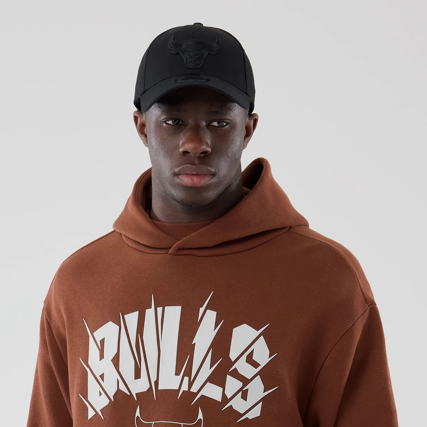 The model is wearing this NBA Core Plus Chicago Bulls Pullover Hoodie in brown. 3