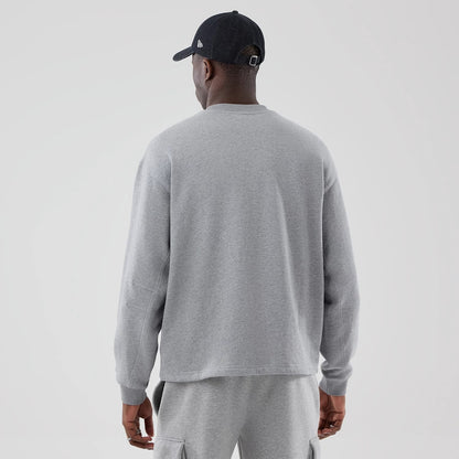The model is wearing this New Era Oversized Crew Neck Sweater in grey. 2