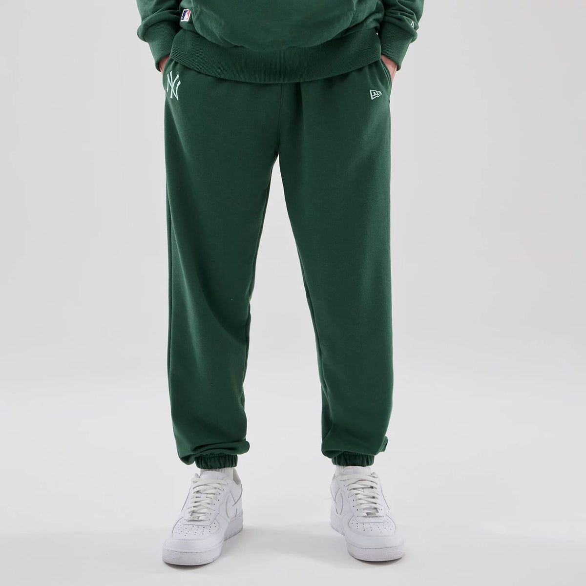 The model is wearing these MLB Midi League Essential New York Yankees Joggers in dark green. 1