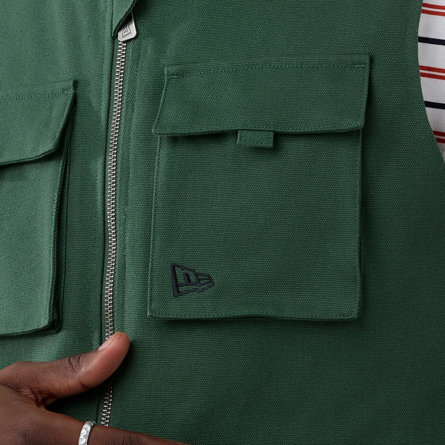 The model is wearing this New Era Utility Vest in dark green. 7