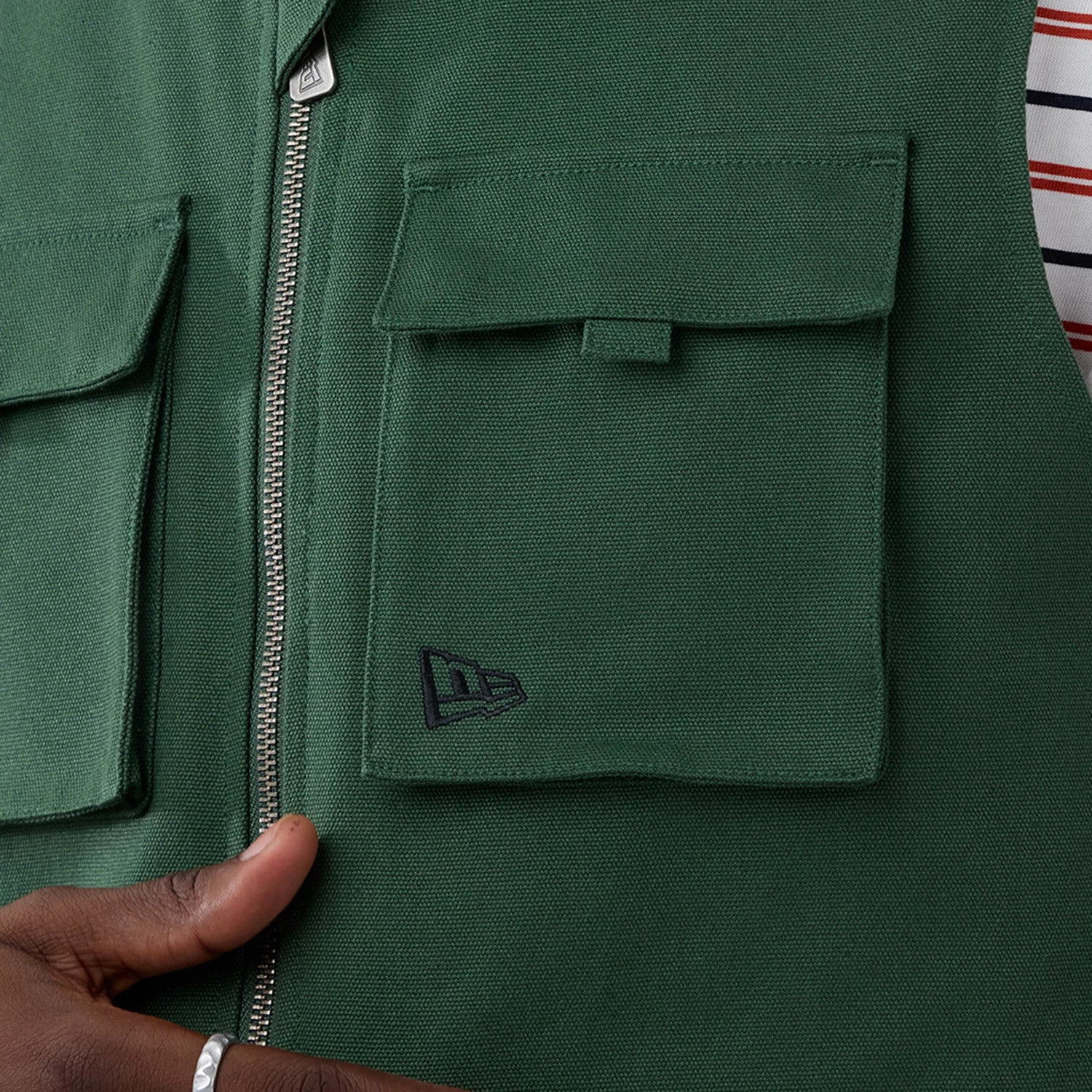 The model is wearing this New Era Utility Vest in dark green. 7