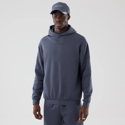 The model is wearing this New Era Tech Oversized Pullover Hoodie in grey. 1